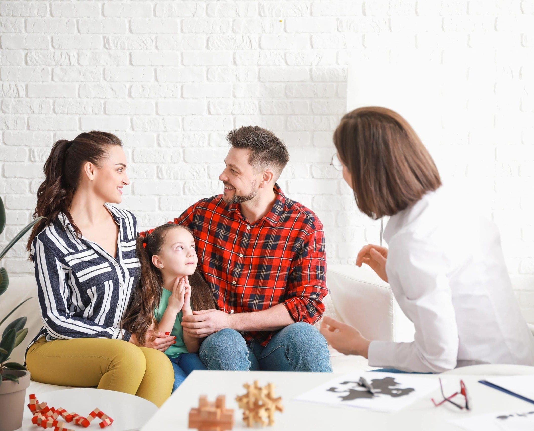 Building a Better Connection Takes Time with Counselor sitting with parents and child in a comfortable, bright counseling room. Building a Better Connection Takes Time with Counselor sitting with parents and child in a comfortable, bright counseling room.